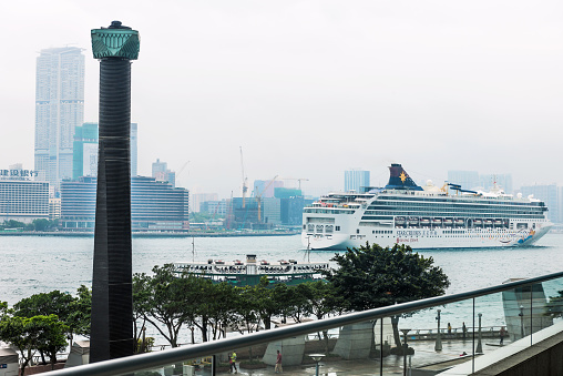 Hong Kong, China - May 3rd, 2014: Superstar Virgo Cruise Ship at the Ocean Terminal on the Kowloon Peninsula,lighthouse in the backgrounds.