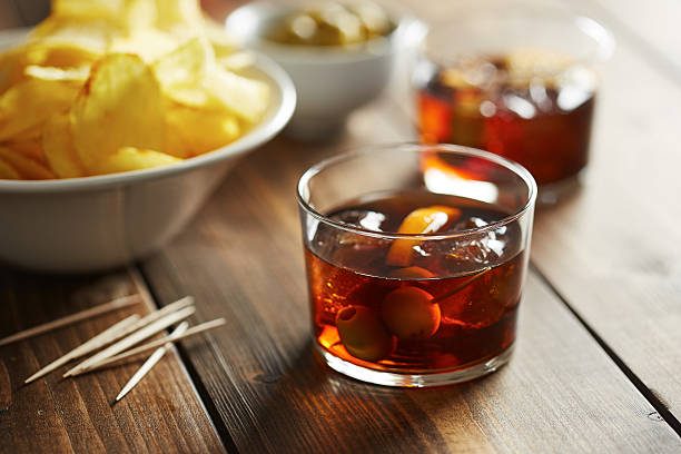Glass of vermouth with nibbles Beer glass with appetizers such as olives, potato chips and mussels vermouth stock pictures, royalty-free photos & images