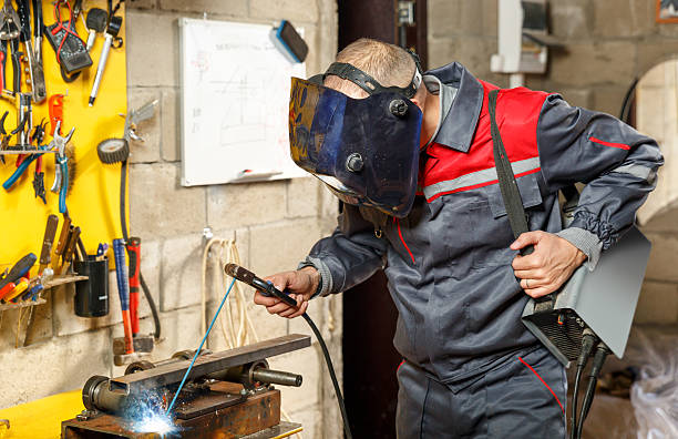 istock Welder worker in protective mask welding metal 467578350