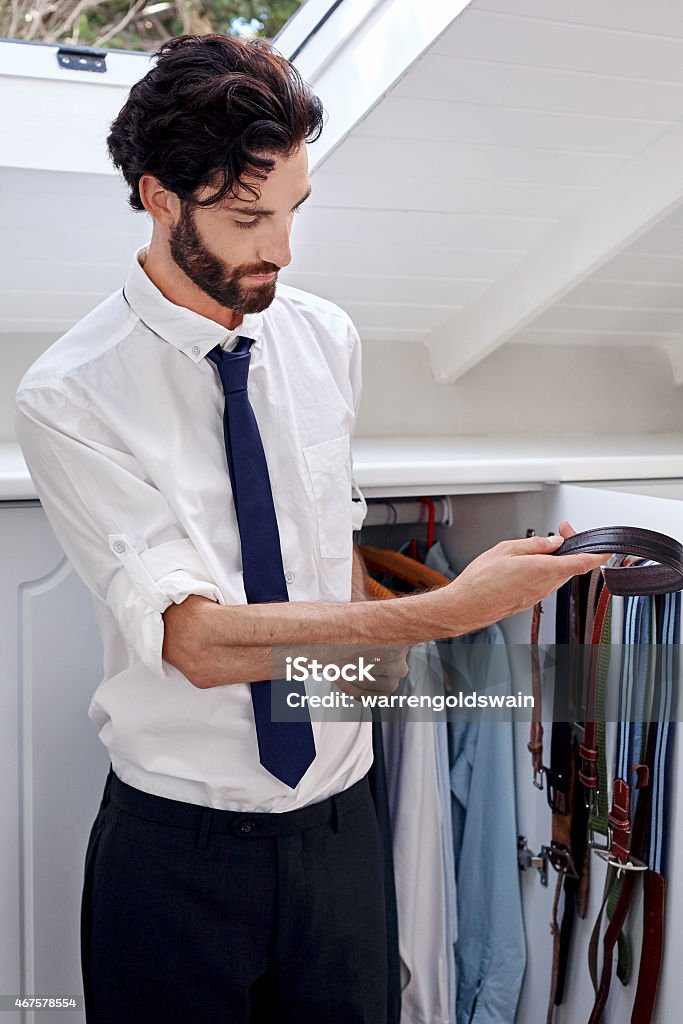 man choosing belt professional man getting ready for work choosing belt from bedroom cupboard 2015 Stock Photo