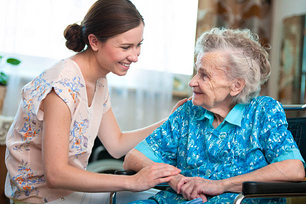 senior frau mit altenpfleger - community outreach home caregiver care cheerful stock-fotos und bilder