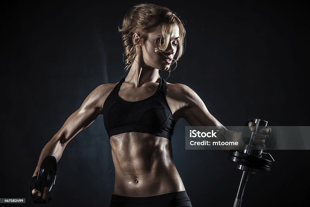 Fitness with barbell Brutal athletic woman pumping up muscules with barbell Gym Stock Photo