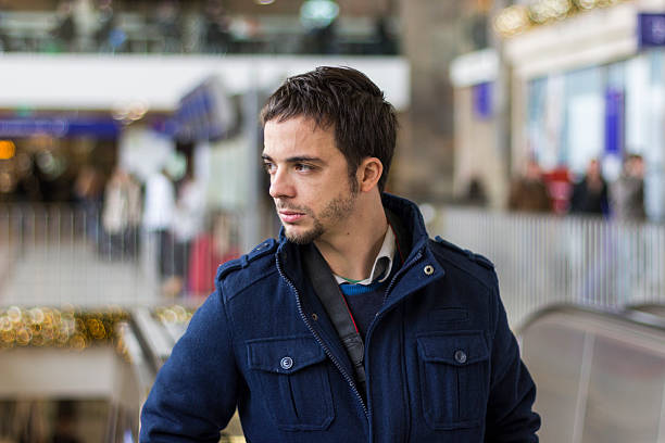 Man with backpack on a city break, standing in the street market and looking up, vacation in oriental city