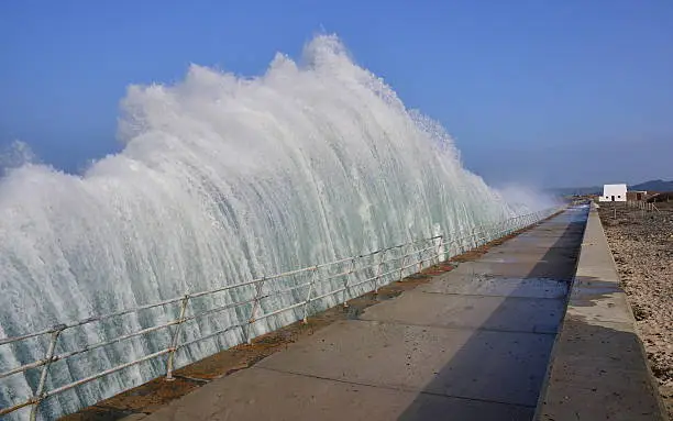 Wide angle image of a Tsunami like wall of water hitting the promenade like a steam train.