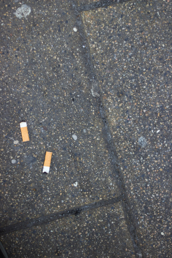 Cigarette Butt Discarded Outdoors On The Floor Of A Granite.