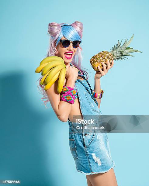 Pink Hair Girl In Manga Outfit Holding Pinapple And Babanas Stock Photo - Download Image Now