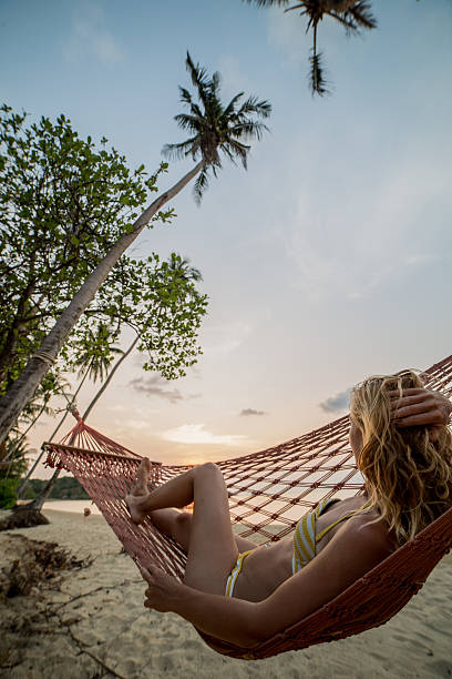 istock Young woman on tropical beach relaxing on hammock 467587184