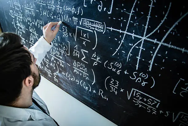 A scientist in front of a blackboard filled with formulas and equations