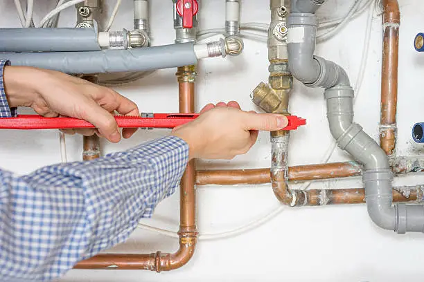 Photo of plumber fixing central heating system