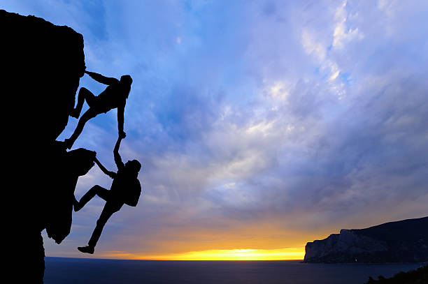 istock Two mountain climbers in silhouette against the sunset 467595960