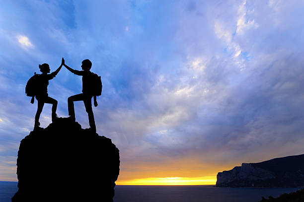 istock work teamwork two men travelers help other top mountain climbing 467595962