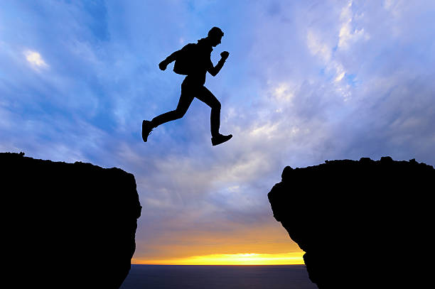 istock Running jumping man above sunset and mountain. sport 467595964