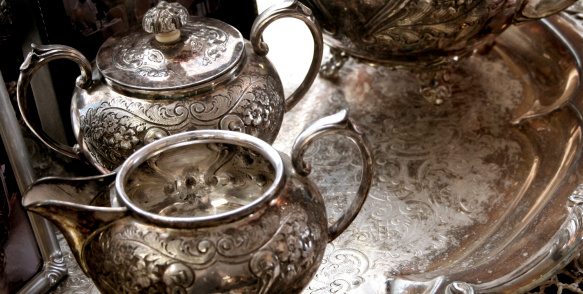 very old and ornate silver tea service, sugar and creamer on a large silver tray with carvings all over, very decorative