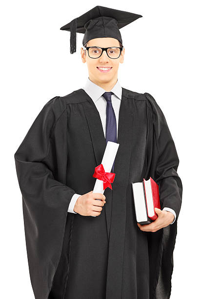istock Male student in graduation gown posing with a diploma 467603949