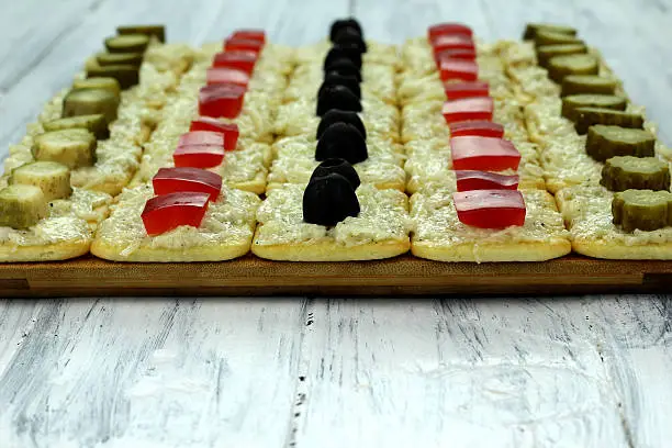 colorful crackers with olives, cucumbers, red pepper  