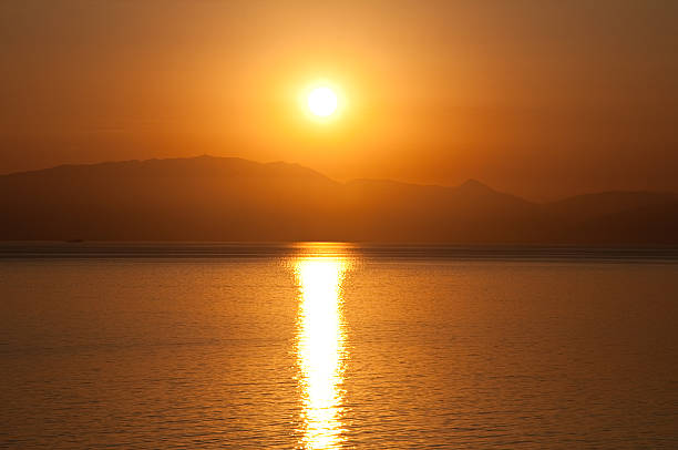 восход солнца в воде. греция. - europe sunlight river sun стоковые фото и изображения