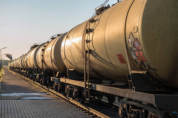 Train pulling long row of oil and fuel in round tanks stock photo