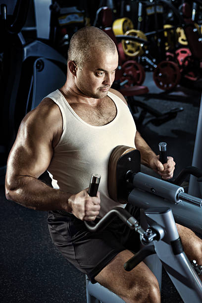 homem fazendo exercício com cama de máquina - human muscle men weights picking up - fotografias e filmes do acervo