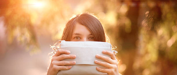 menina hidding segurando uma bolsa - hidding imagens e fotografias de stock