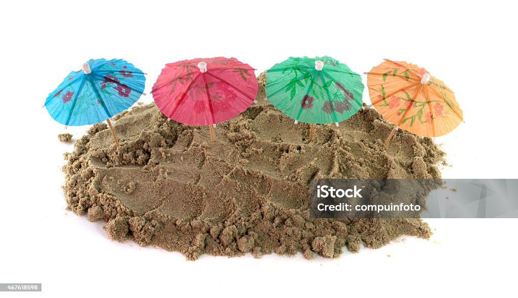 Cocktail Umbrella in Sand Mound green blue red and green cocktail Umbrellas in Sand Mound 2015 Stock Photo