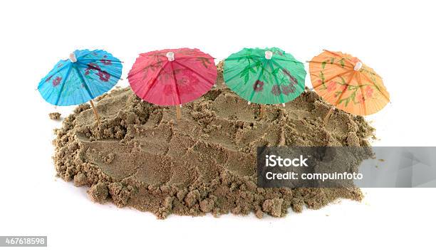 Cocktail Umbrella In Sand Mound Stock Photo - Download Image Now - 2015, Beach, Beach Party