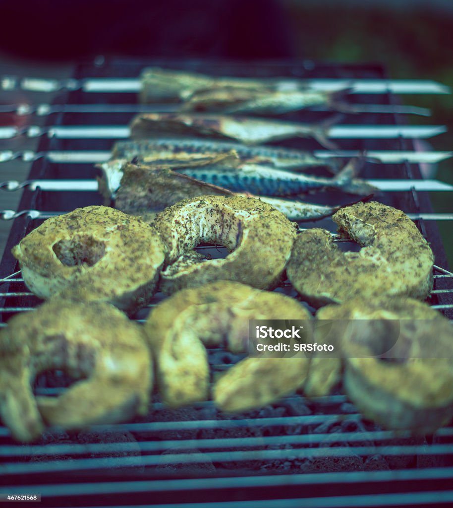 fish on grill fish, barbecue grill, grilled, prepared fish, coal, cooking, salmon, barbecue, flame, fire, summer, smoke, meat, food and drink, food, activity, break, domestic life, roasted, resting, refreshment, relaxation, metal, portion, outdoors, close up 2015 Stock Photo