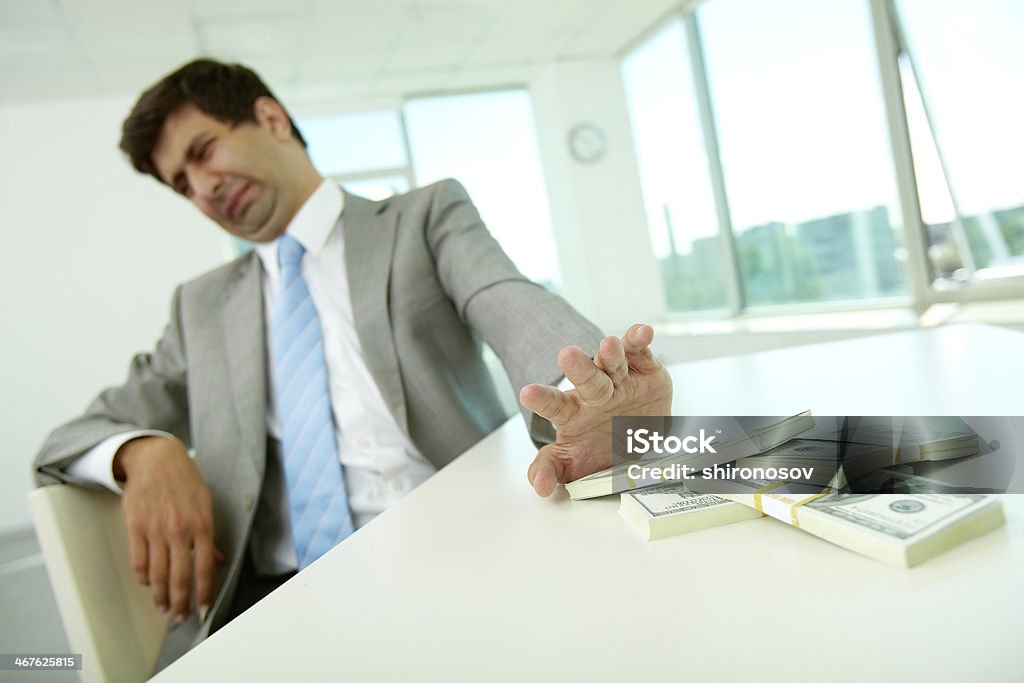 Rejection Image of disgusted male employee moving dollar bills away and refusing to take bribe Currency Stock Photo