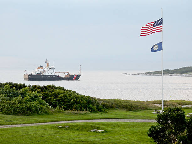 Virginia Beach, Virginia, USA - April 13, 2024: Historic lightkeepr homes at historic Cape Henry surround a modern harbor control tower topped by a multitude of communications and radar equipment.