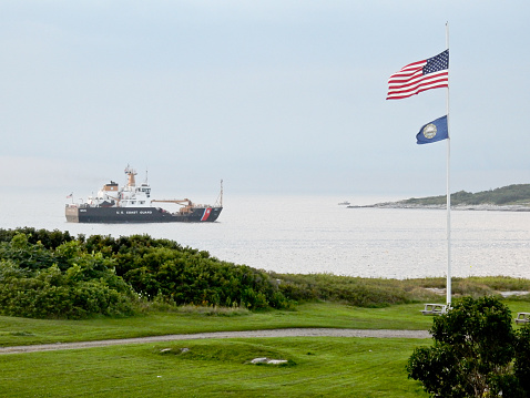 Rye, NH, USA - August 6, 2014: US Coast Guard buoy tender Marcus Hanna enters Gosport Harbor on a stormy summer evening.