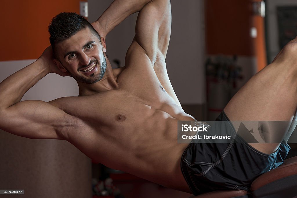 Sonriente hombre haciendo ejercicios abdominales - Foto de stock de 20-24 años libre de derechos