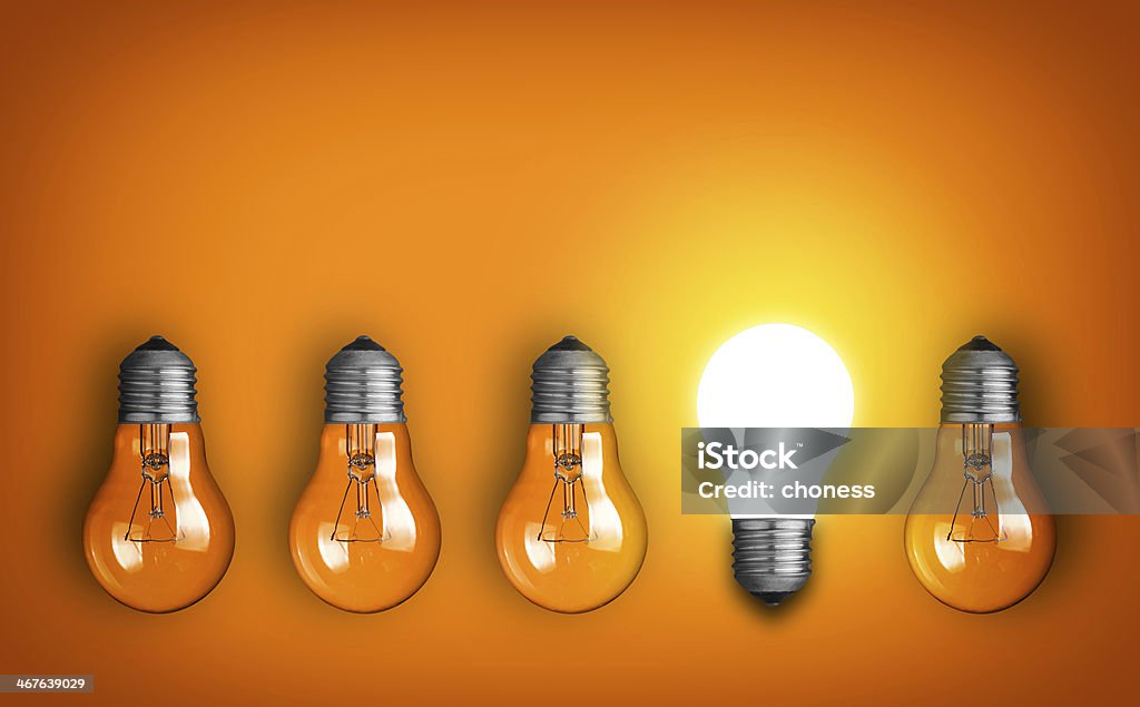 Idea concept row of light bulbs and glowing bulb Light Bulb Stock Photo