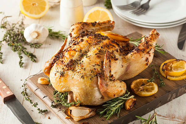 istock Lemon and herb whole chicken on wooden board 467639190