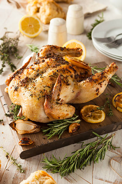 istock Lemon and herb chicken on a wood cutting board with spices  467639254