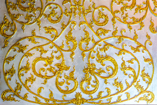detail of Thai pattern on temple pavilion wall in Buddhist temple of Thailand