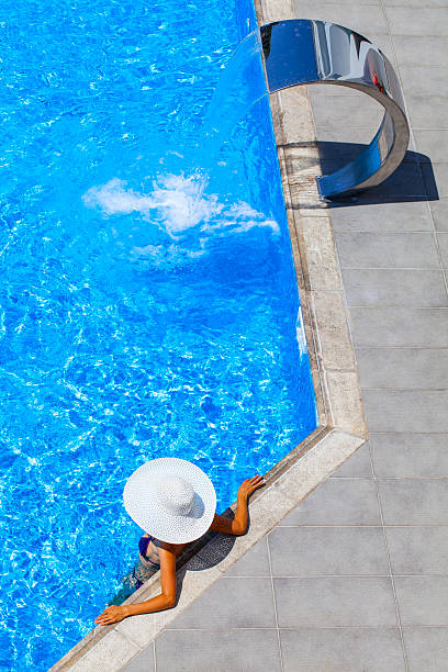 istock woman relaxing at a resort swimming pool 467640074