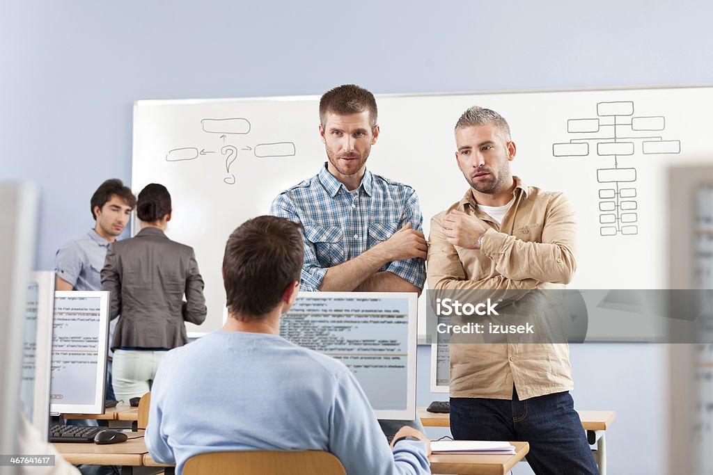 Adult education Group of adult students attending a job training. Focus on three discussing men. 30-39 Years Stock Photo