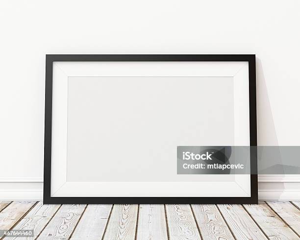 An Empty Black Picture Frame Leaning Against A Wall Stock Photo - Download Image Now