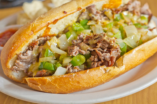 Philly Cheesesteak with diced onions peppers and mushrooms with tortilla chips and salsa on the side