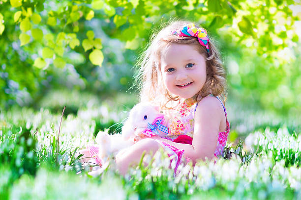 istock Beautiful little girl playing with a rabbit 467648472