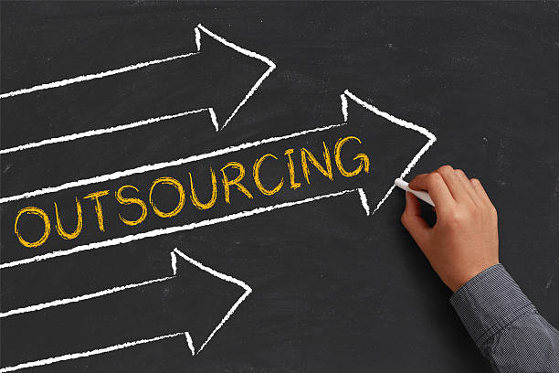 Outsourcing Abstract A businessman is drawing Outsourcing concept with arrows on blackboard. paintball photography stock pictures, royalty-free photos & images