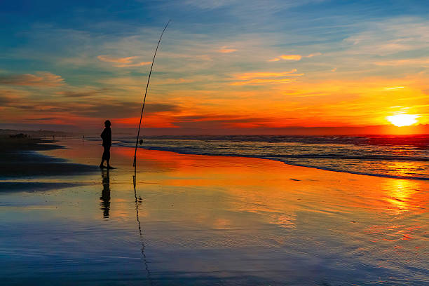 istock One person surfcasting at sunset on the beach 467648985