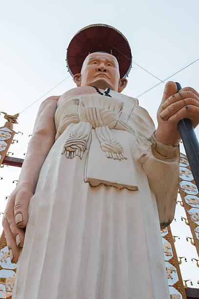 istock buddhist monk in white robe statue with walking stick 467652088