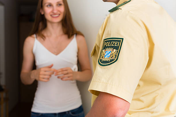 istock Police officer interrogation woman at front door 467654373