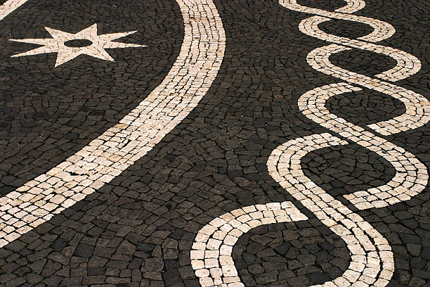 Portuguese black and white mosaic pavement. Typical old Portuguese black and white stone mosaic "calcada" pavement in undulating geometrical pattern and star - Ponta Delgada, Azores Islands. art and craft product stock pictures, royalty-free photos & images