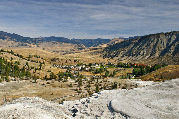 Minerva Terrace and Mammoth Hot Springs Minerva Terrace is the most famous feature of the Mammoth Hot Springs complex. It is a series of travertine terraces on a hill close to the historic Fort Yellowstone. The hot springs were created over thousands of years as hot water from the spring cooled and deposited calcium carbonate. The hot water that feeds Mammoth Hot Springs travels underground from Norris Geyser Basin via a fault line. The limestone from rock formations along the fault is the source of the calcium carbonate. Algae living in the warm pools have tinted the travertine shades of brown, orange, red, and green. Due to recent earthquake activity, the spring has shifted causing the terraces to become dry. Mammoth Hot Springs is in Yellowstone National Park, Wyoming, USA. jeff goulden yellowstone national park stock pictures, royalty-free photos & images