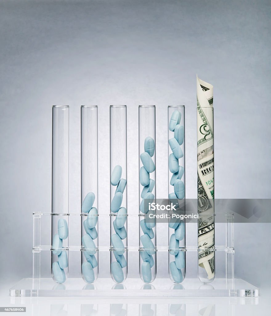 Pharmaceutical research costs Rolled up US paper banknote in a test tube rack representing the costs of medical research Currency Stock Photo