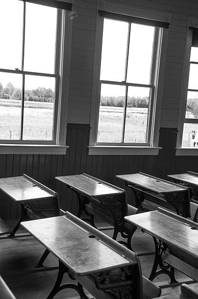 istock Vintage  schoolhouse classroom with student desks- black and white 467659114