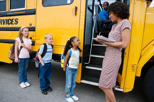 istock Children Standing In A Line By School Bus 467677378
