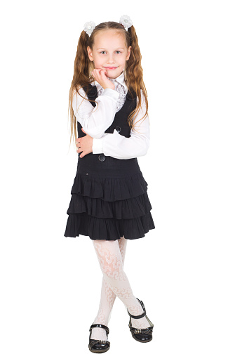 Full length portrait of a young smiling girl in school uniform isolated on white background