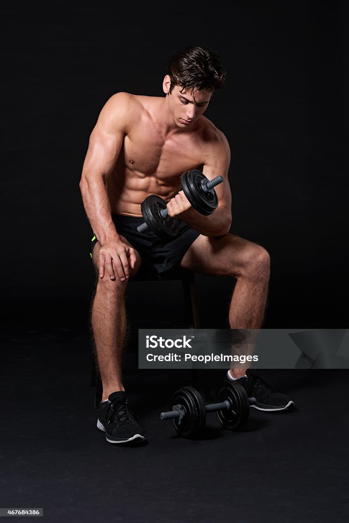 Making every rep count Studio shot of a young man working with dumbbells isolated on blackhttp://195.154.178.81/DATA/istock_collage/0/shoots/785361.jpg Men Stock Photo